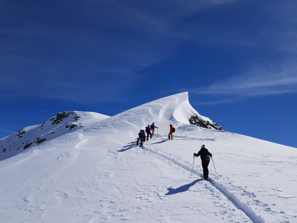 belle-randonnee-de-groupe-en-haute-montagne-avec-neige-fraiche-et-soleil
