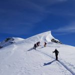 belle-randonnee-de-groupe-en-haute-montagne-avec-neige-fraiche-et-soleil